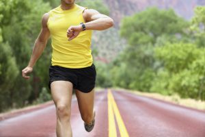 Runner with heart rate monitor sports watch. Man running looking at his pulse outside in nature on road. Similar: